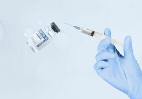 Hand holding syringe and vaccine vial